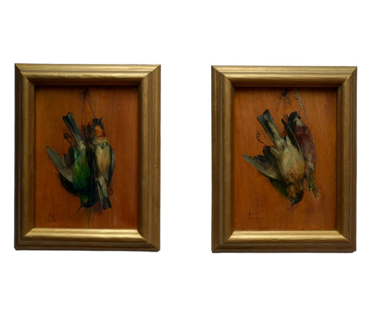 Two framed artworks of birds on a light blue wall
