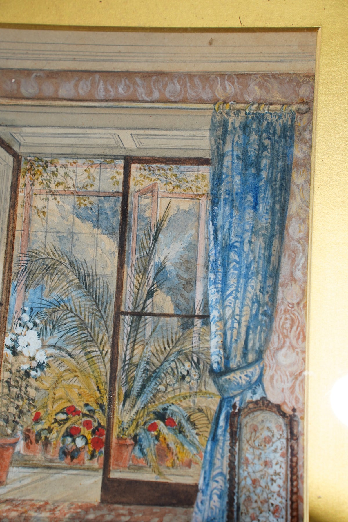 A framed art print depicting a classical interior scene with blue patterned curtains, a floral window treatment, and a bed, shown hanging on a yellow wall.